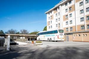 a white bus parked in front of a building at Venice Hotel Albatros in Mestre