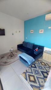 a blue couch in a living room with a blue wall at R&R GESTHOUSE in Shirokë +145 photos