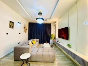 a living room with a couch and a tv at Bumcy Apartment in Ankuru +5 photos