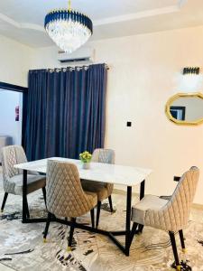 a dining room with a table and chairs and a chandelier at Bumcy Apartment in Ankuru