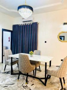 a dining room with a table and chairs and a chandelier at Bumcy Apartment in Ankuru