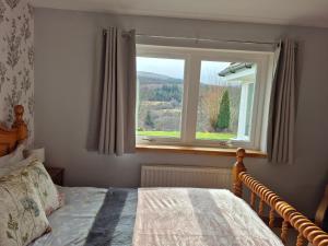 a bedroom with a bed and a window at The Studio in Drumnadrochit