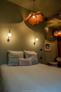 a bedroom with a large bed with two pillows at Les gîtes de la Grange de Léonie - jacuzzis privatifs et Piscine in Vierzon +85 photos