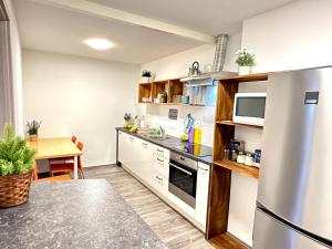 a kitchen with white cabinets and a stainless steel refrigerator at Rookos rooms in Ljubljana