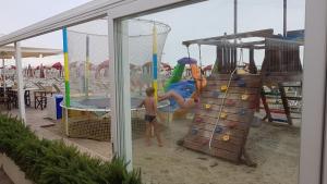 two young boys playing on an outdoor playground at Casa Vacanze Zadina in Cesenatico