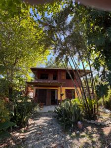 a house in the middle of a yard with trees at Casa Almendros in Cabuya