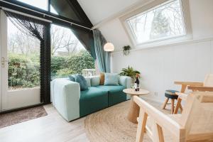 a living room with a blue couch and a table at Jonkerstee 59 - Ouddorp in Ouddorp