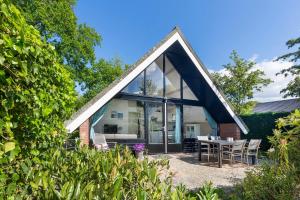 a house with glass doors and a table and chairs at Jonkerstee 59 - Ouddorp in Ouddorp