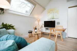 a living room with a couch and a tv at Jonkerstee 59 - Ouddorp in Ouddorp