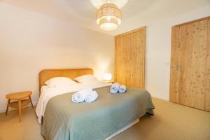 a bedroom with a bed with two towels on it at Alpine Panorama Spacious Mountain Retreat in Crans-Montana