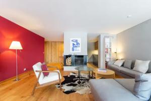 a living room with a couch and a table at Alpine Panorama Spacious Mountain Retreat in Crans-Montana