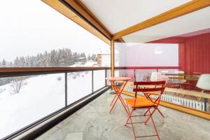 a room with a balcony with a table and chairs at Alpine Panorama Spacious Mountain Retreat in Crans-Montana