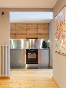 a kitchen with stainless steel appliances and wooden cabinets at Alpine Panorama Spacious Mountain Retreat in Crans-Montana +7 photos