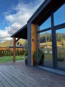 a large glass door on a wooden deck at Osho house Karpaty in Ilʼtsya Dolishna