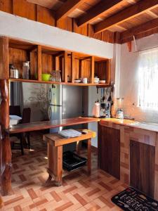 a kitchen with wooden cabinets and a wooden table at Casa Almendros in Cabuya +51 photos