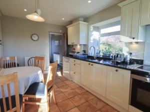 a kitchen and dining room with a table and a window at 2 Lupton Hall Cottages in Carnforth