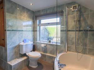a bathroom with a toilet and a tub and a sink at 2 Lupton Hall Cottages in Carnforth +26 photos