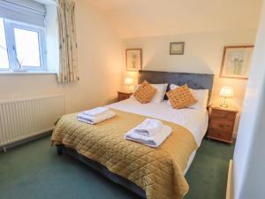 a bedroom with a bed with towels on it at 2 Lupton Hall Cottages in Carnforth