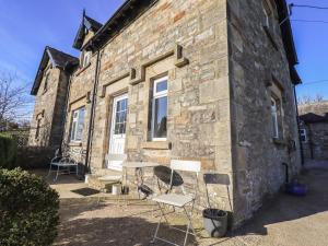 a table and chairs outside of a stone house at 2 Lupton Hall Cottages in Carnforth