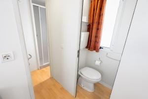 a small bathroom with a toilet and a window at Camping Il Boschetto Di Piemma in San Gimignano +38 photos