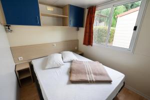 a small bedroom with a bed with a towel on it at Camping Il Boschetto Di Piemma in San Gimignano