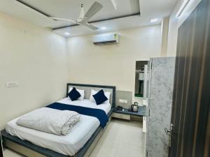 a bedroom with a bed with blue and white sheets at Hotel Pujari in Khātu