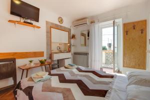 a living room with a bed and a table and a window at Apartments Tasha in Štivan