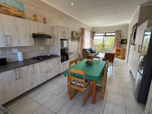 a kitchen with a green table in a room at Hettie's Cottage in Hartenbos