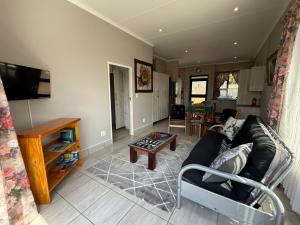 a living room with a couch and a table at Hettie's Cottage in Hartenbos