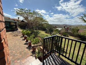 a balcony with a fence and potted plants at Hettie's Cottage in Hartenbos