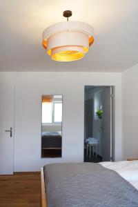 a bedroom with a bed and a light fixture at Penthouse mit Panoramaterrasse & Bergblick in Landquart in Landquart
