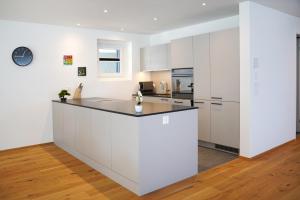 a kitchen with white cabinets and a counter top at Penthouse mit Panoramaterrasse & Bergblick in Landquart in Landquart