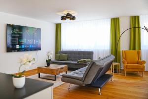 a living room with a couch and a chair at Penthouse mit Panoramaterrasse & Bergblick in Landquart in Landquart