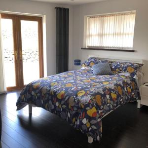 a bedroom with a bed with a colorful comforter at The Walnut Retreat Castlewellan in Ballyward +25 photos