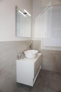 a white bathroom with a sink and a mirror at Colli Apartment Lake Como in Malgrate +37 photos