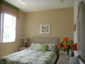 a bedroom with a bed and a vase of flowers at My Florida Lake House in Homestead