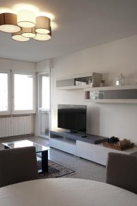 a living room with a television and a table at Colli Apartment Lake Como in Malgrate