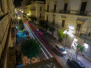 una strada di città di notte con auto parcheggiate sulla strada di Ajde rooms & breakfast a Trani