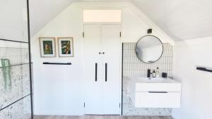 a bathroom with a sink and a mirror at Lorraine Loft Apartment in Gqeberha +32 photos