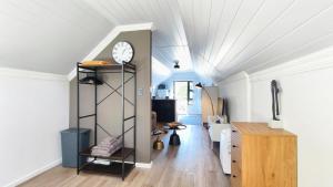 a living room with a clock on a wall at Lorraine Loft Apartment in Gqeberha