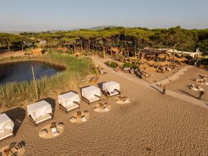 an overhead view of a beach with white tables and chairs at NOMAD ARGENTARIO - Area Sosta Camper - NO TENDE - NO CARAVAN - Empty Pitch Only Campervan RV - SOLO PIAZZOLA PER IL PROPRIO CAMPER - Tariffa fino a 4 persone - TUTTI I SERVIZI INCLUSI in Albinia