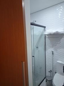 a bathroom with a glass shower and a toilet at Optimum Plaza Hotel in Monte Alto +50 photos