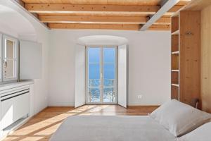 an empty room with a bed and a window at Foresteria Monastero B&B in Mandello del Lario