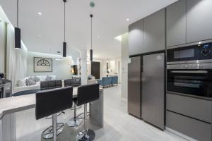 a kitchen with black appliances and a living room at رواء آن للضيافة in Quai