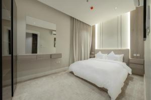 a bedroom with a white bed and a large window at رواء آن للضيافة in Quai
