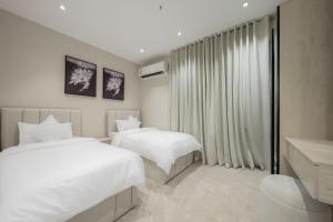 a hotel room with two beds and a window at رواء آن للضيافة in Quai