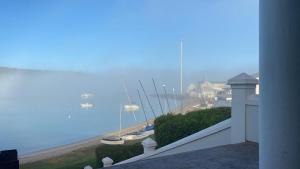 a balcony with a view of a beach and boats at House with Those Stairs in Langebaan +4 photos