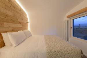 a bedroom with a white bed with a window at Killarney Glamping - Ross Road in Killarney