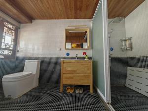 a bathroom with a toilet and a sink at Baisha Holiday Resort Lijiang in Lijiang +69 photos