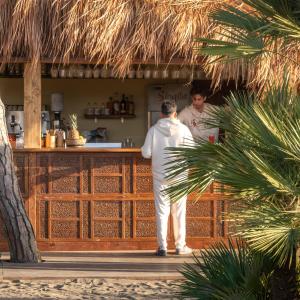 a man standing in front of a bar at NOMAD ARGENTARIO - Area Sosta Camper - NO TENDE - NO CARAVAN - Empty Pitch Only Campervan RV - SOLO PIAZZOLA PER IL PROPRIO CAMPER - Tariffa fino a 4 persone - TUTTI I SERVIZI INCLUSI in Albinia +56 photos